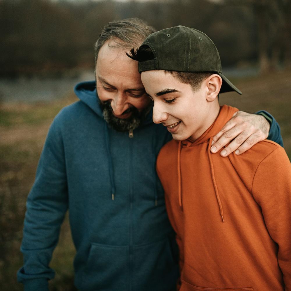 A man and young person smile while on a walk