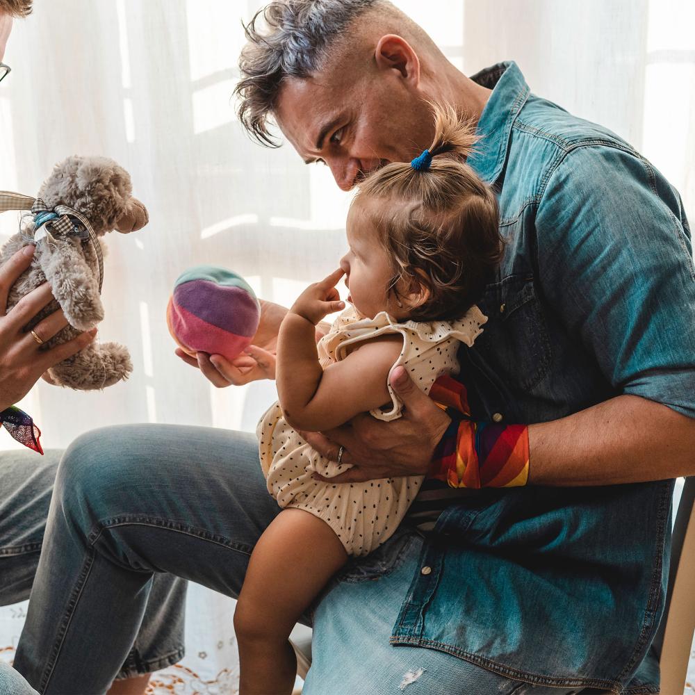 Male couple playing with toddler