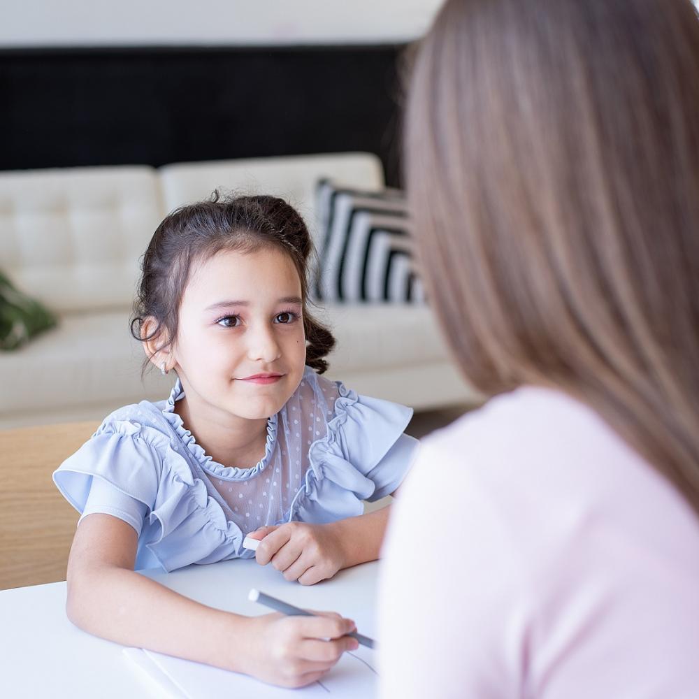 Young girl looking at a social worker across table