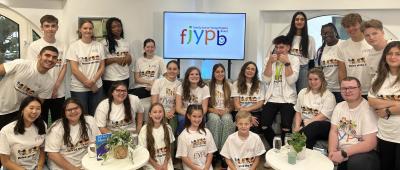 Group of young people gathered in front of screen in office